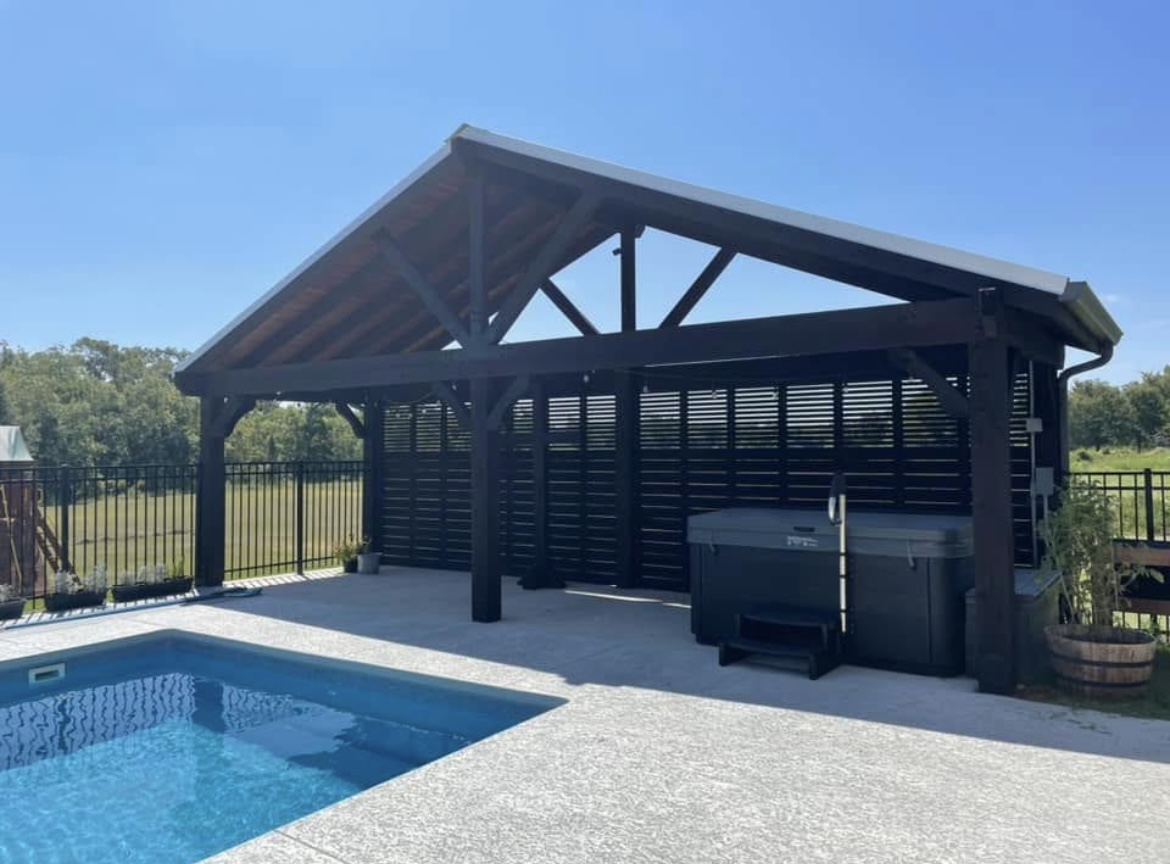 Dark stained pergola beside a pool built by Tejas Construction